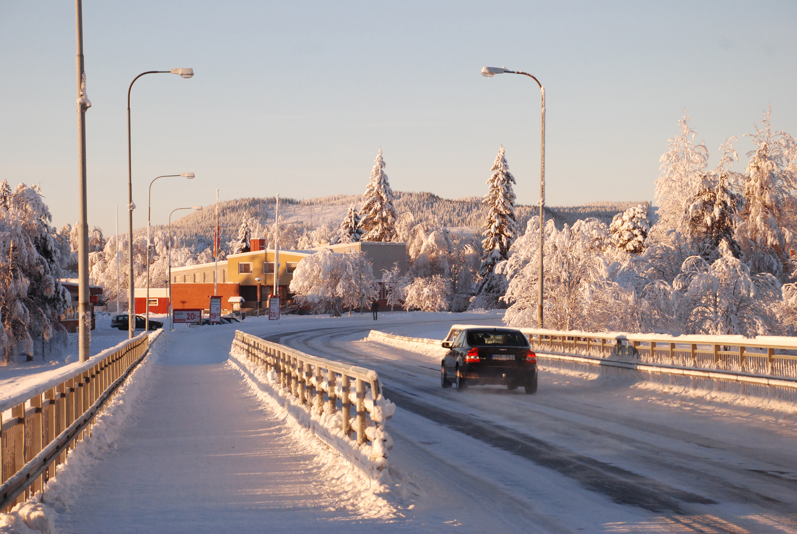 Bil kör över en snöig bro